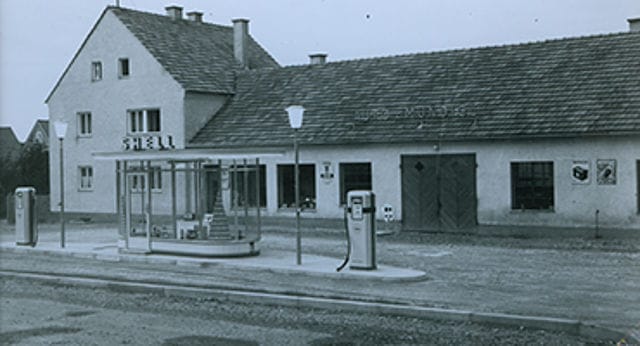 Historisches Schwarz-Weiß-Foto: die Anfänge von Mundigl in Vilsbiburg mit Werkstatt und Shell-Tankstelle