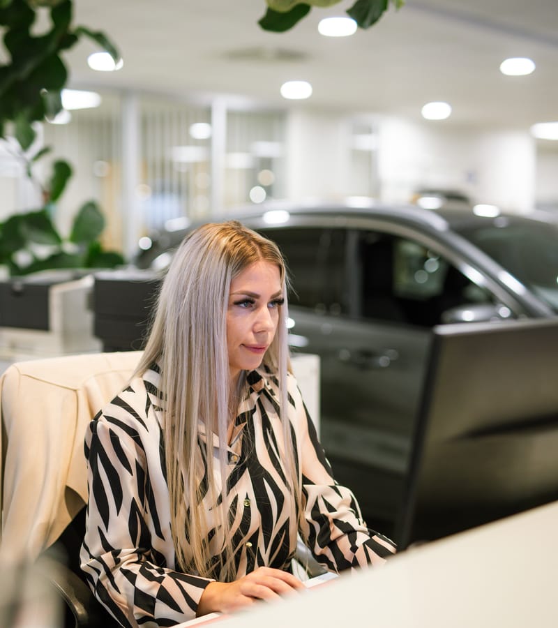 Eine Kollegin an ihrem hellen Arbeitsplatz im Autohaus