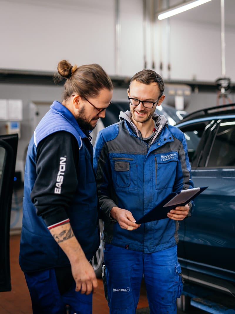 Zwei Kollegen besprechen sich mit einem Tablet in der Werkstatt