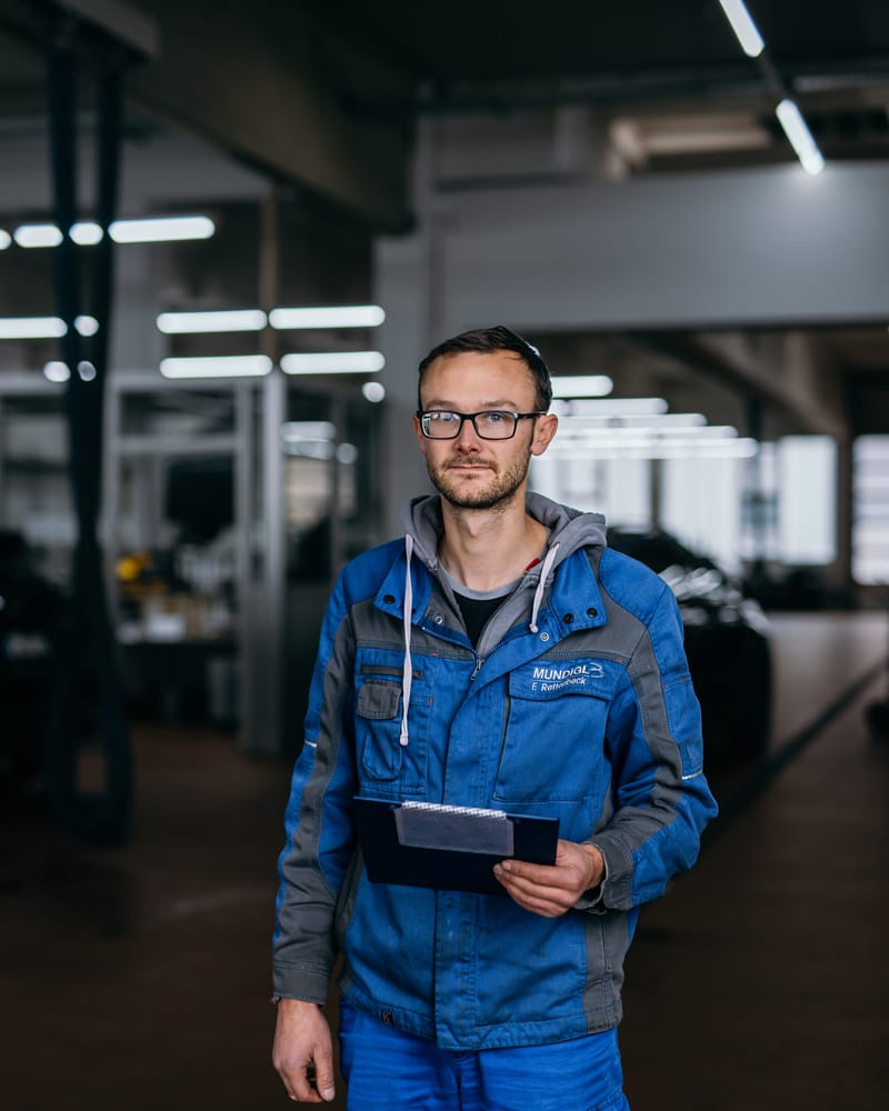 Ein Kfz-Meister mit Tablet in der Werkstatthalle