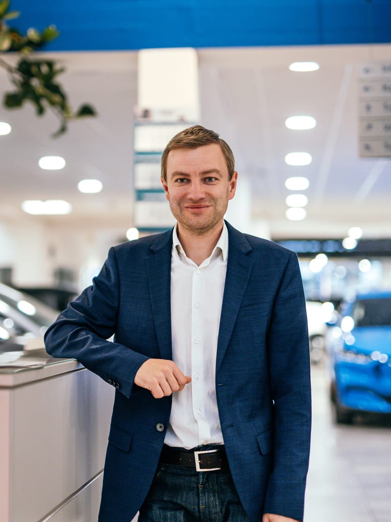 Max Mundigl, Geschäftsführer, an der Theke unter dem Ford-Logo